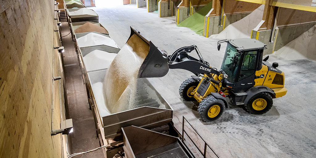 Front loader empties crop nutrients in full warehouse