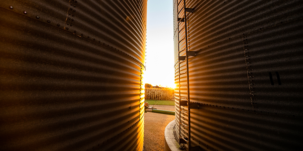 View of sunset between two large grain bins