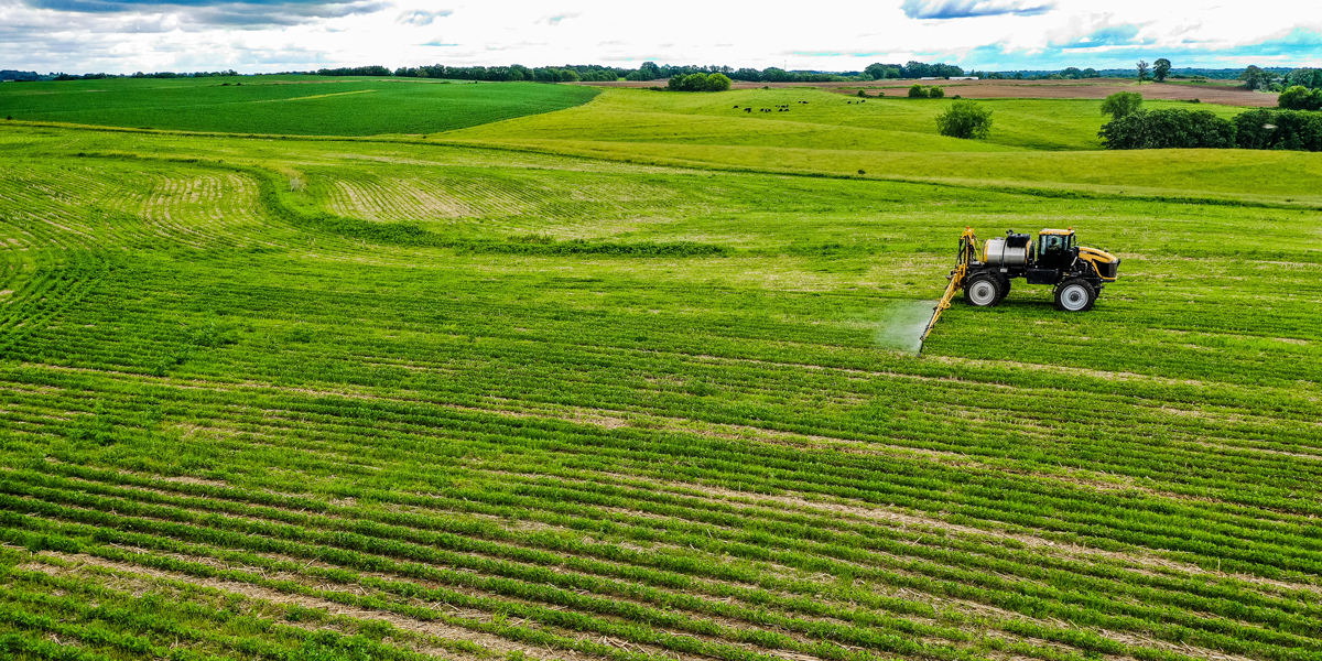 Aerial view of a tractor spraying a young field