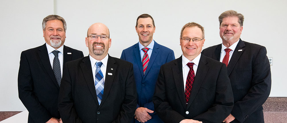 New CHS Board Members wearing suits, smiling and standing in two rows